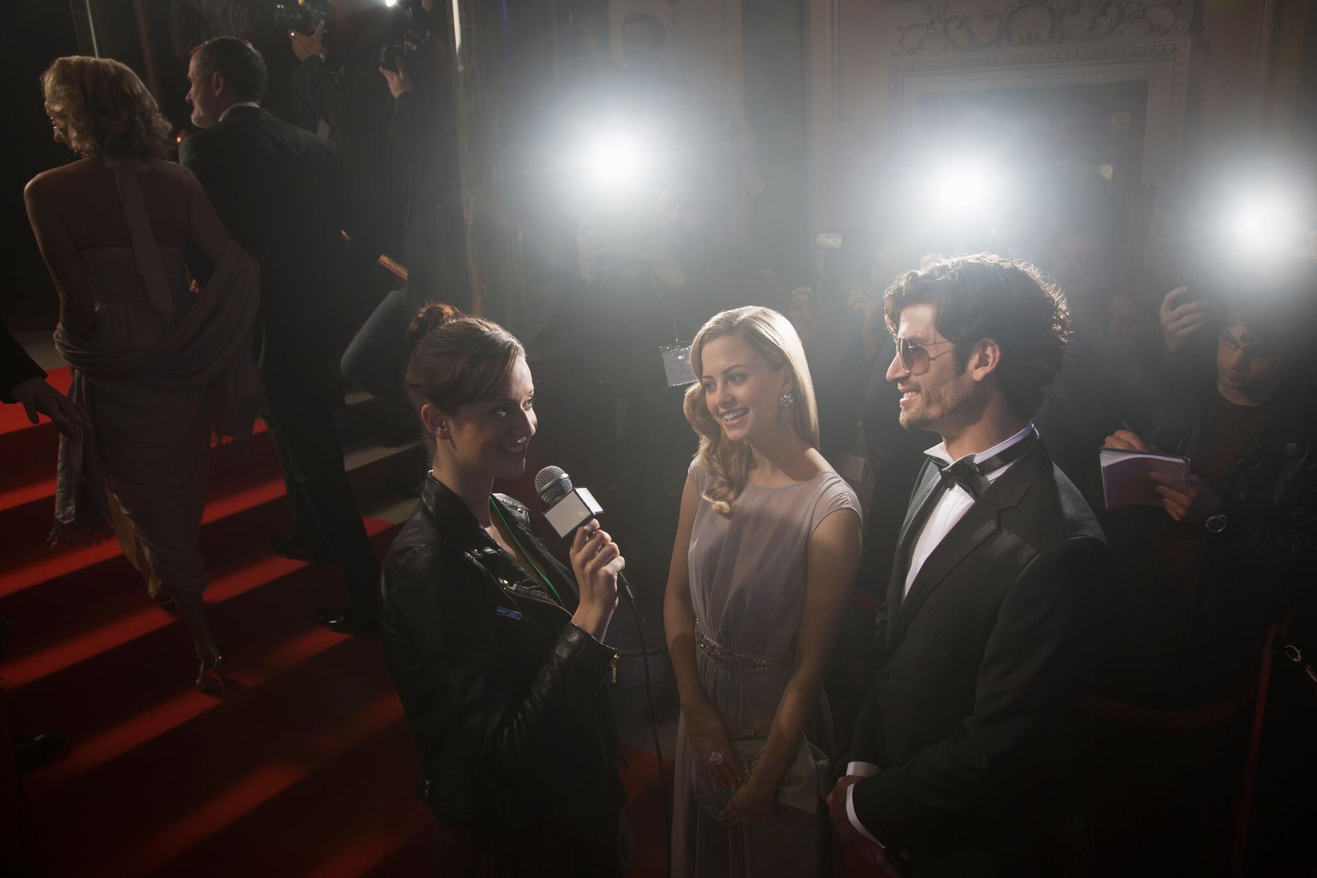 Celebrity couple being interviewed on red carpet