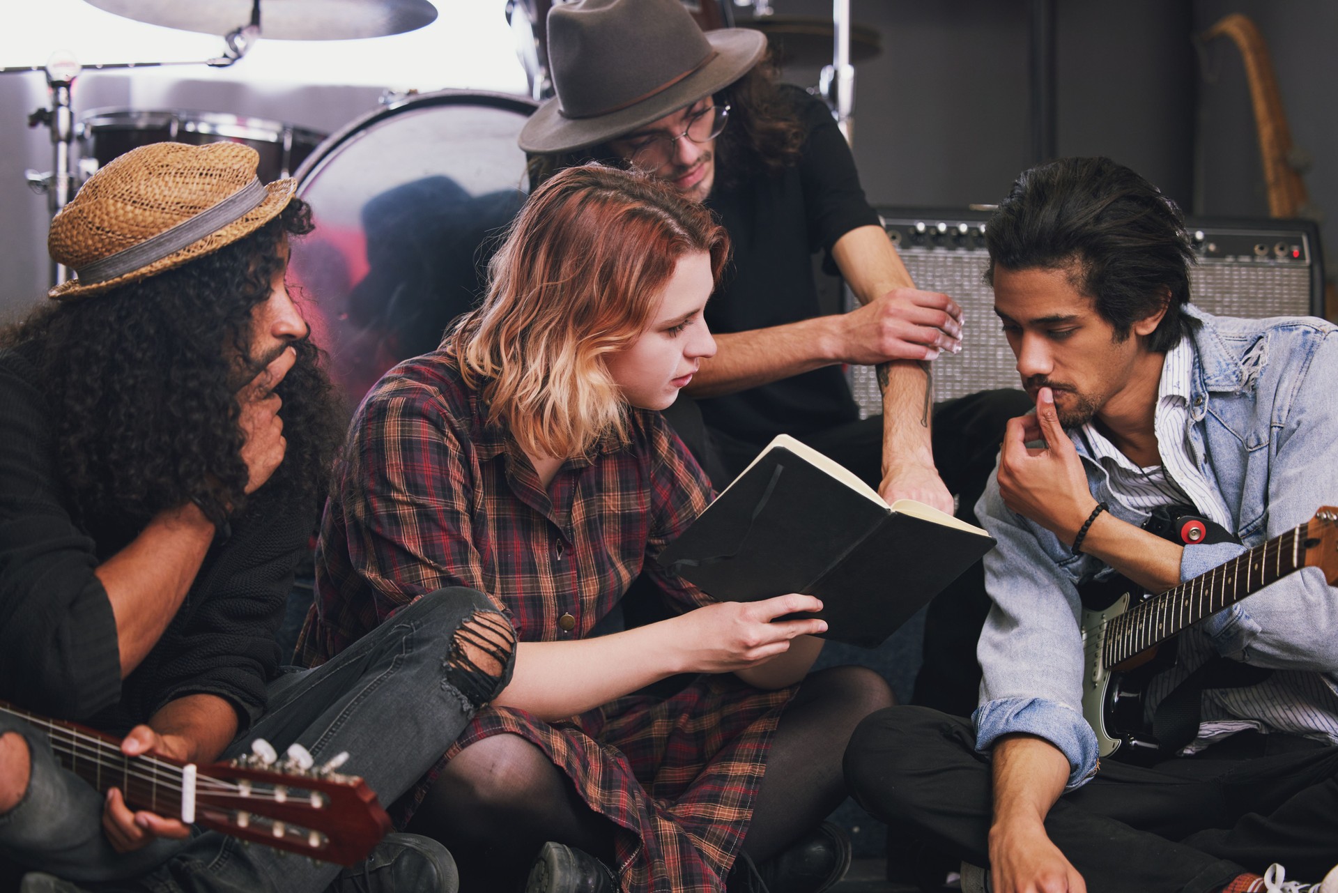 Shot of a diverse group of musicians sitting in the studio together and brainstorming a song