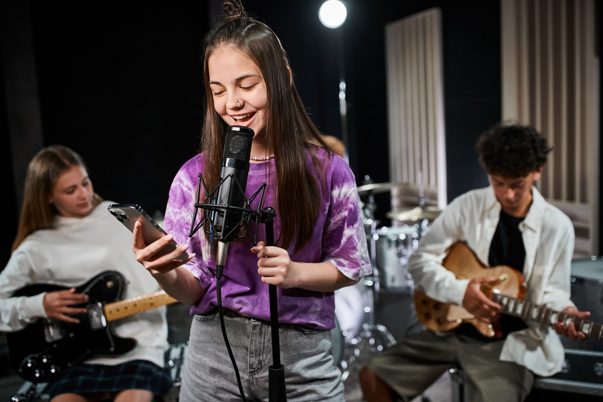 Teen musicians practice in a studio, showcasing their talent and creativity